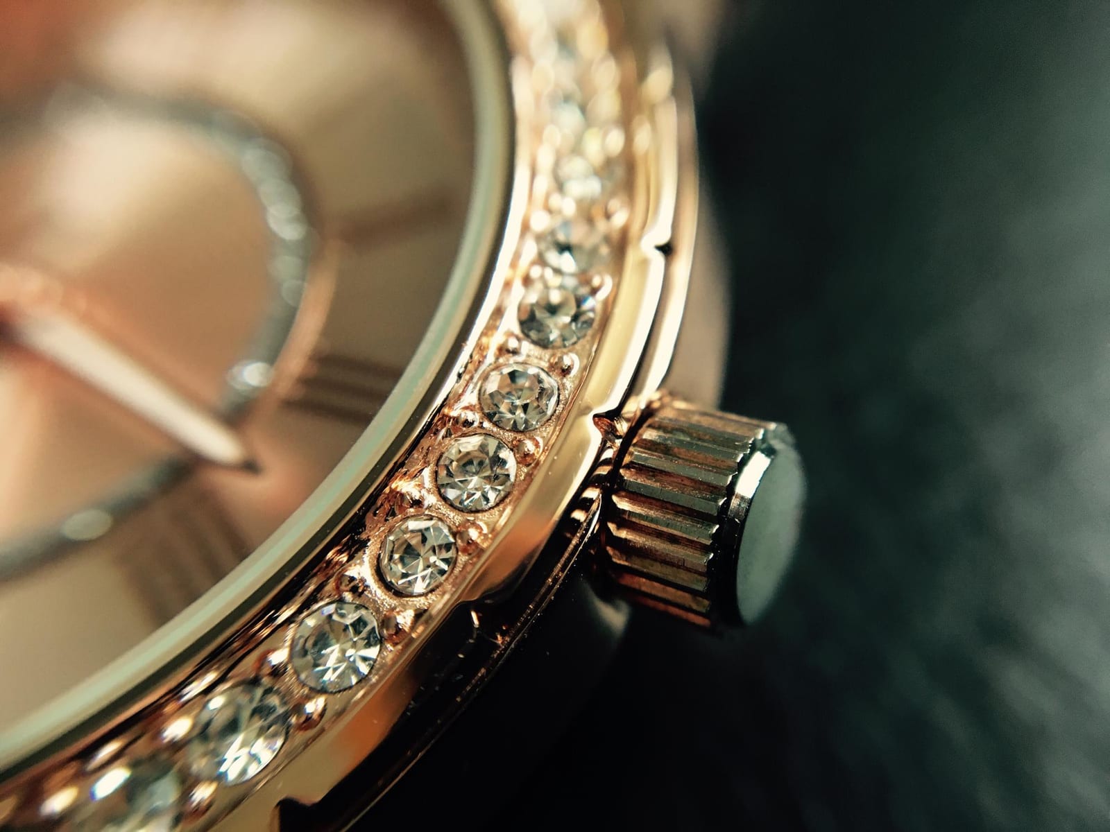 Orologiaio al banco che osserva un movimento meccanico appena estratto dalla cassa, sotto una lampada da lavoro