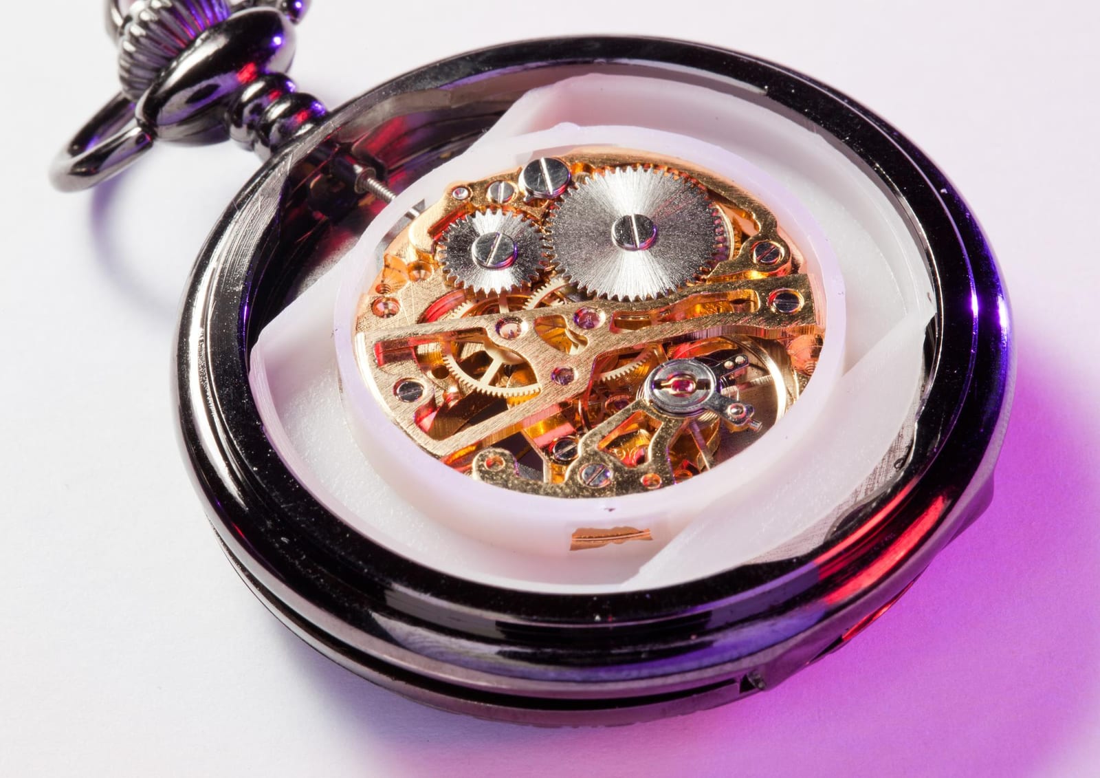 Movimento dorato di un orologio da tasca aperto, visibile attraverso il fondello
